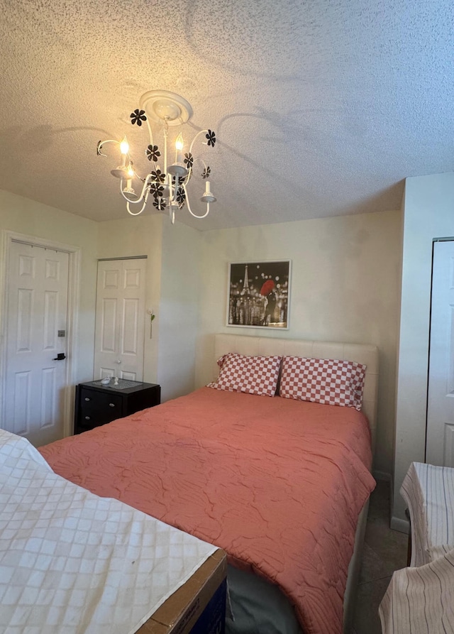 carpeted bedroom with a textured ceiling and a chandelier