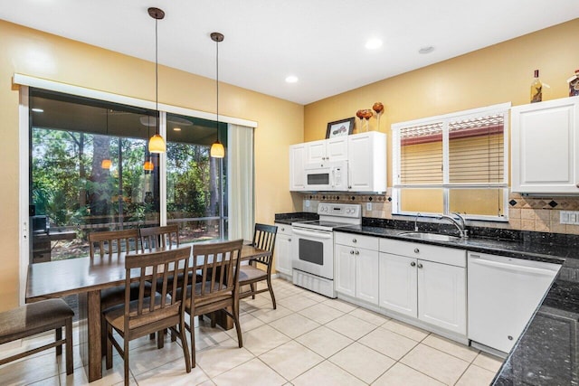 kitchen with backsplash, sink, decorative light fixtures, white cabinetry, and white appliances