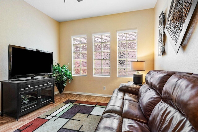 living room with light hardwood / wood-style flooring and ceiling fan