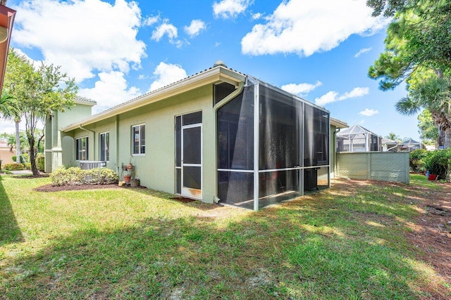 view of home's exterior with a yard and a sunroom