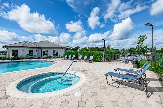 view of swimming pool with a patio and a hot tub