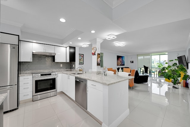 kitchen with decorative backsplash, white cabinetry, kitchen peninsula, ornamental molding, and stainless steel appliances