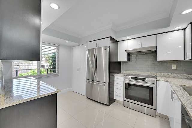 kitchen with light tile patterned floors, decorative backsplash, appliances with stainless steel finishes, ornamental molding, and white cabinetry