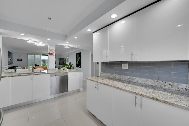 kitchen with backsplash, sink, white cabinetry, stainless steel dishwasher, and light stone counters