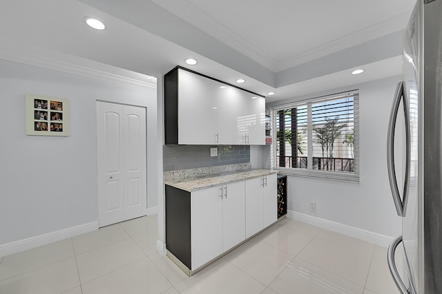 kitchen with tasteful backsplash, white cabinetry, light tile patterned floors, and stainless steel fridge