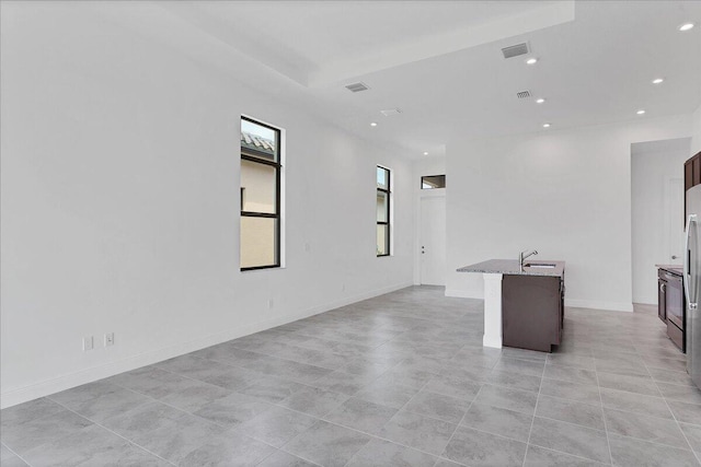 spare room featuring light tile patterned floors and sink