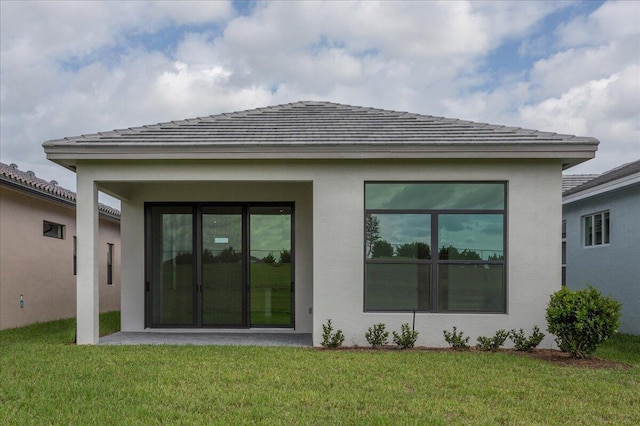 rear view of property featuring a lawn