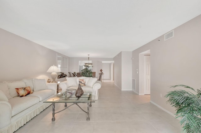 living room featuring a notable chandelier and light tile patterned floors