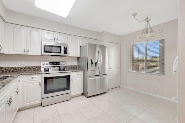 kitchen with decorative light fixtures, stainless steel appliances, white cabinetry, and light tile patterned flooring