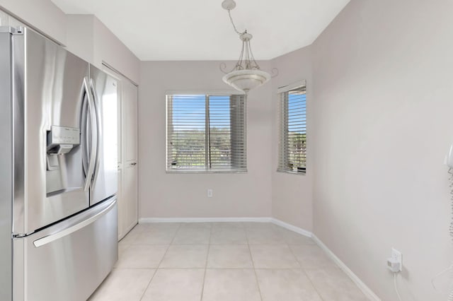 kitchen featuring decorative light fixtures, stainless steel fridge, and light tile patterned floors