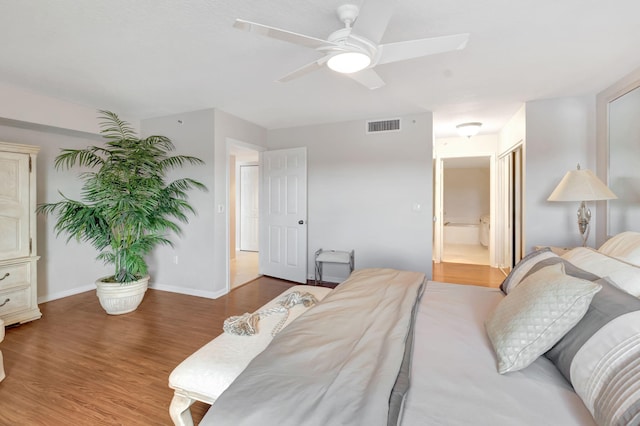 bedroom featuring hardwood / wood-style flooring, connected bathroom, and ceiling fan