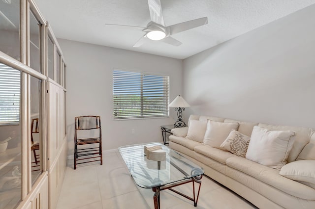 tiled living room with a textured ceiling and ceiling fan