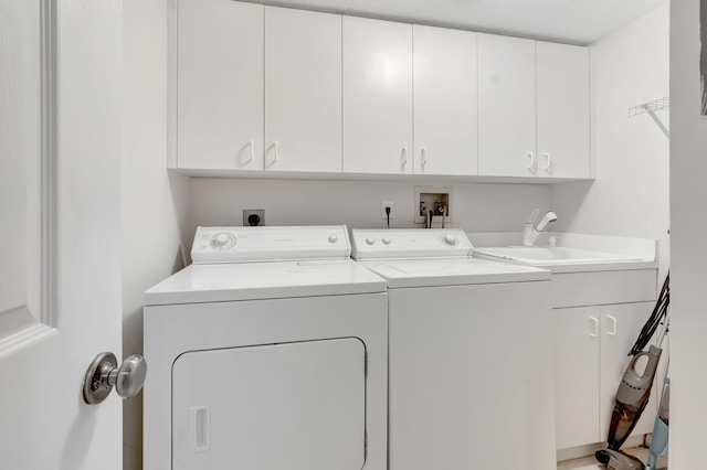 laundry area with separate washer and dryer, cabinets, and sink