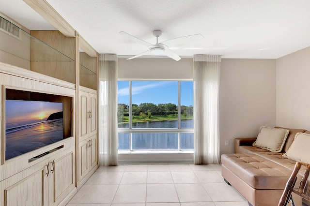 tiled living room featuring a water view and ceiling fan