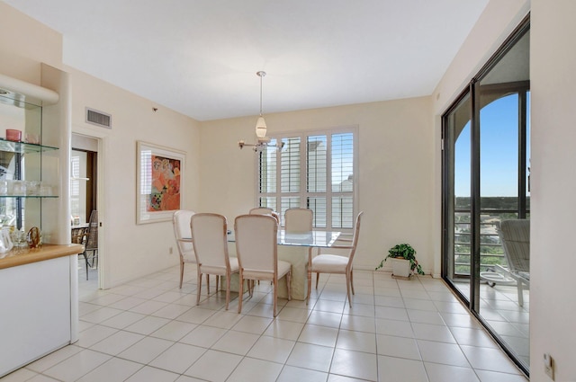 dining room featuring a wealth of natural light, visible vents, an inviting chandelier, and light tile patterned flooring