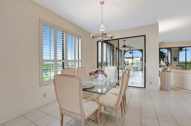 dining area with light tile patterned floors, baseboards, a wealth of natural light, and ceiling fan with notable chandelier