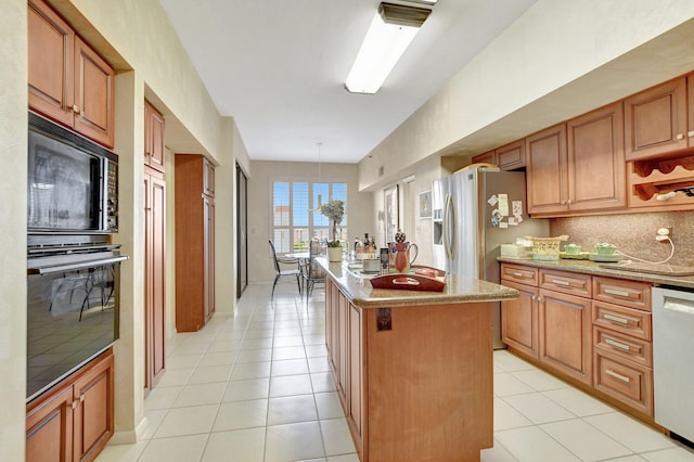 kitchen featuring hanging light fixtures, brown cabinetry, dishwasher, and a center island