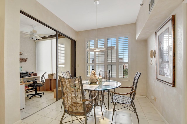 dining space featuring light tile patterned floors, ceiling fan, visible vents, and baseboards