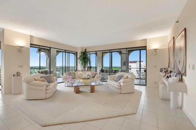 living room featuring ceiling fan, light tile patterned flooring, and a wealth of natural light