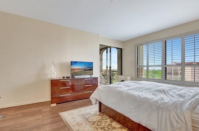 bedroom featuring light wood-style floors and baseboards