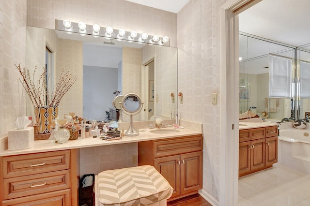 bathroom with tile walls, a bath, and vanity