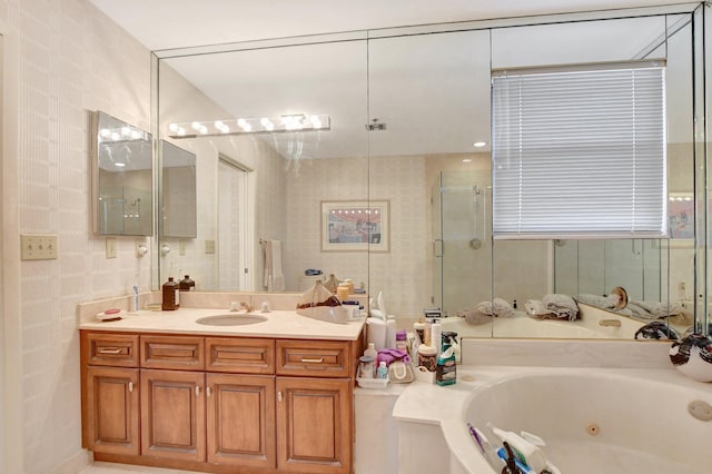 full bath with a tub with jets, a shower stall, and vanity