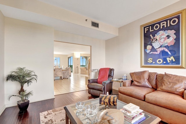 living room with hardwood / wood-style flooring, baseboards, and visible vents