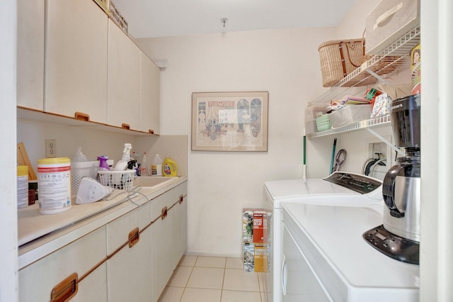 laundry area featuring separate washer and dryer, light tile patterned flooring, and cabinet space