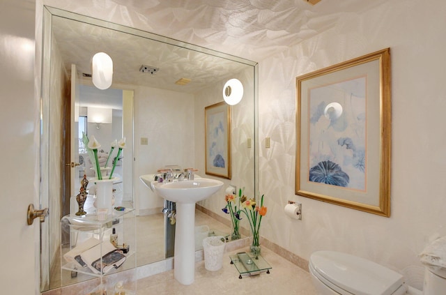 half bath featuring toilet, tile patterned flooring, and baseboards