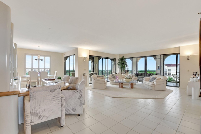 living room featuring light tile patterned floors, an inviting chandelier, and a healthy amount of sunlight