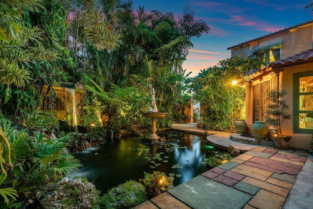 yard at dusk featuring a patio area