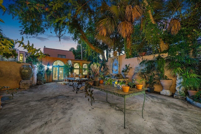 patio terrace at dusk featuring french doors