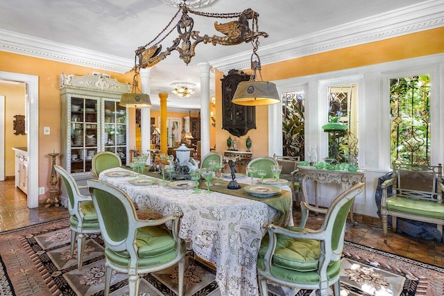 dining area with decorative columns and crown molding