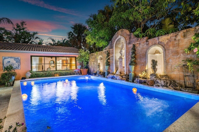 view of pool at dusk