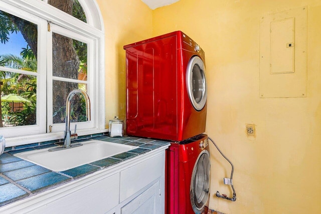 laundry room with stacked washer / dryer, sink, cabinets, and electric panel