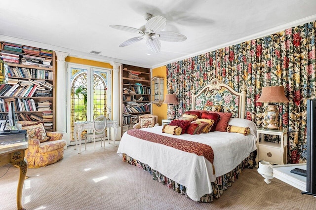 carpeted bedroom featuring ceiling fan, ornate columns, french doors, and ornamental molding