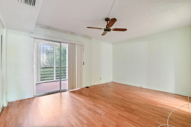 spare room with visible vents, a ceiling fan, and wood finished floors