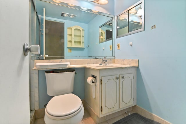 bathroom featuring tile patterned flooring, baseboards, vanity, and toilet