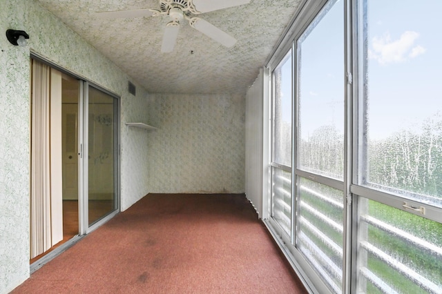 unfurnished sunroom featuring visible vents and a ceiling fan