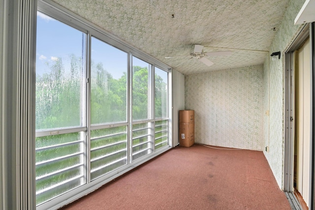 unfurnished sunroom featuring a healthy amount of sunlight and ceiling fan