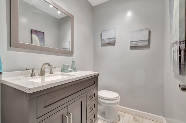 bathroom with hardwood / wood-style floors, vanity, and toilet