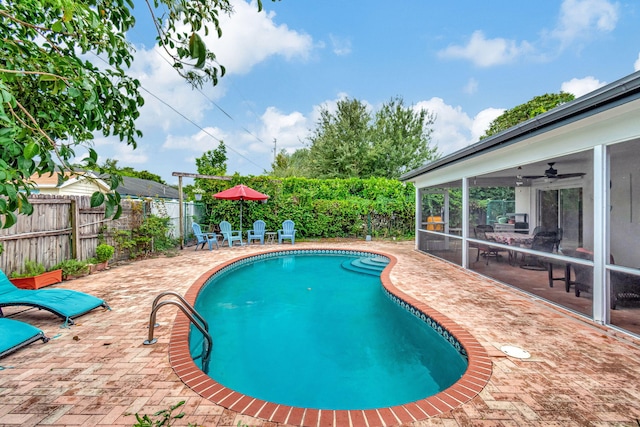 view of swimming pool featuring ceiling fan, a sunroom, and a patio