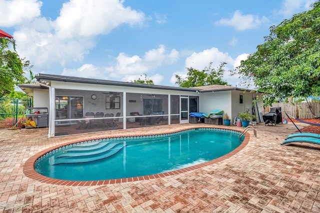 view of pool with a sunroom and a patio area