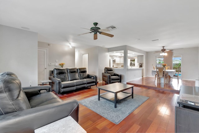 living room featuring wood-type flooring and ceiling fan