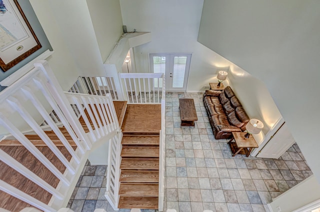 tiled living room with french doors and a high ceiling