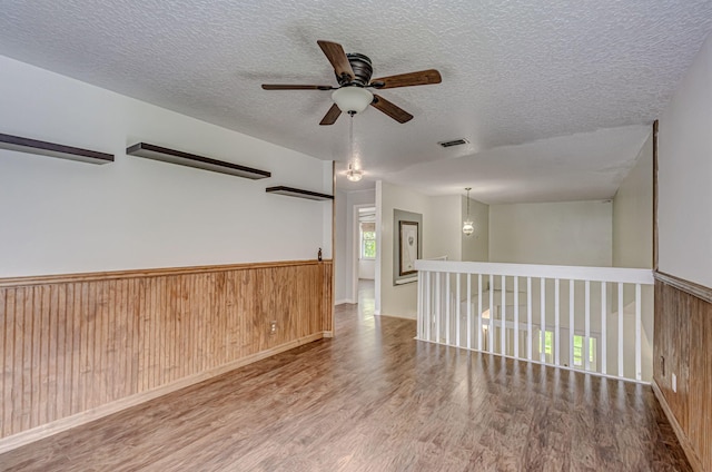 spare room with ceiling fan, hardwood / wood-style flooring, and a textured ceiling