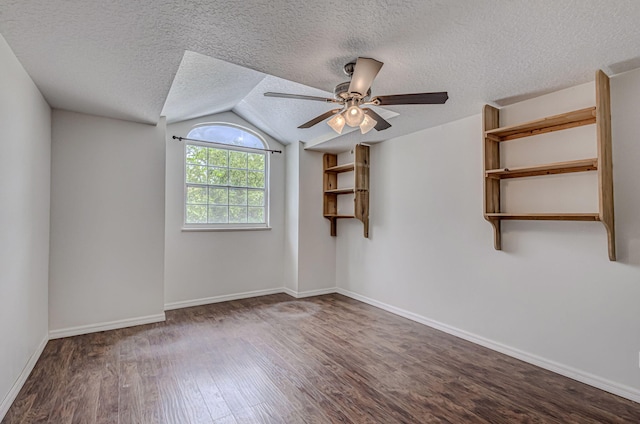 spare room with ceiling fan, a textured ceiling, dark hardwood / wood-style floors, and lofted ceiling