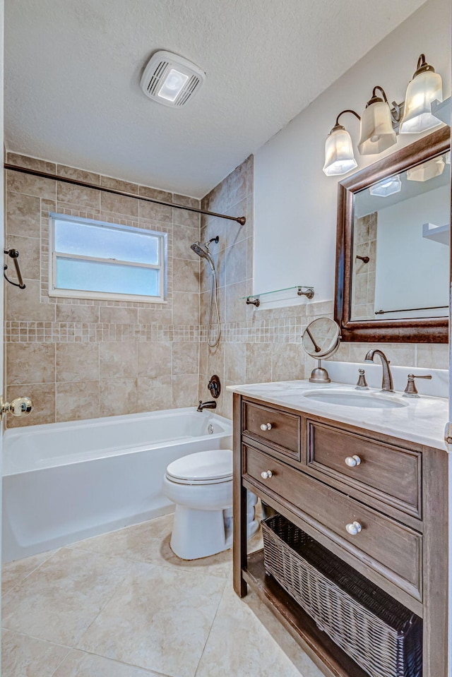 full bathroom featuring vanity, tile patterned floors, a textured ceiling, toilet, and tiled shower / bath combo