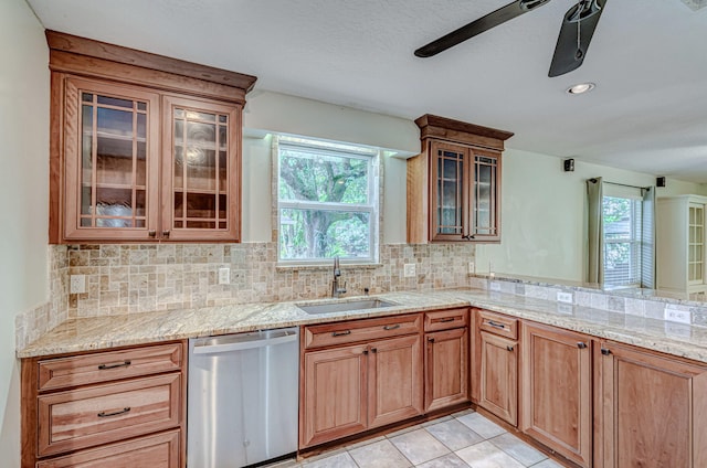 kitchen with stainless steel dishwasher, tasteful backsplash, sink, light tile patterned floors, and ceiling fan