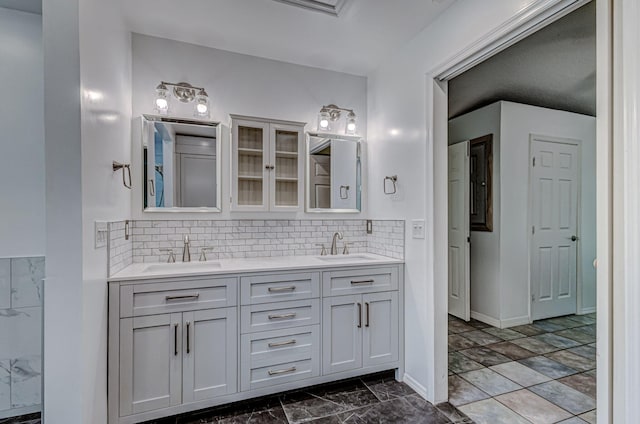 bathroom with tile patterned floors, tasteful backsplash, and dual bowl vanity